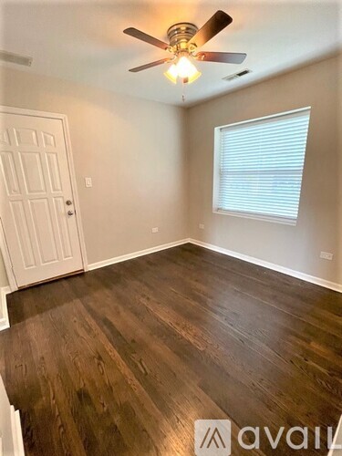 A room with wooden flooring and a ceiling fan.