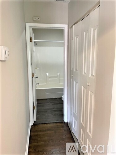 A hallway with white doors and a glass door leading to a bedroom.