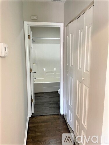 A hallway with white doors and a glass door leading to a bedroom.