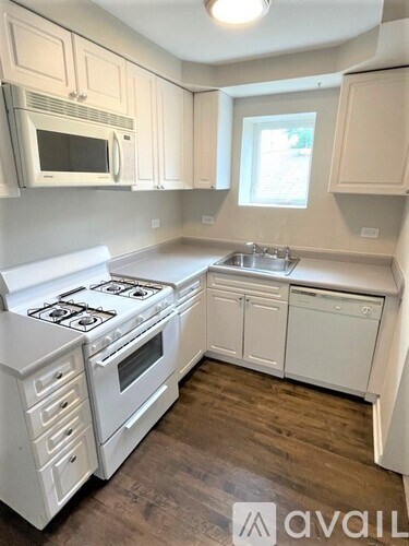 A kitchen with white cabinets and a stove top oven.