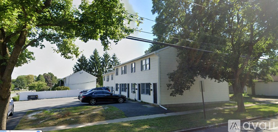 A car is parked in front of a house with a sign that says "AVAILABLE".