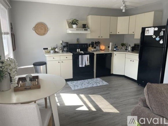 A kitchen with black appliances and white cabinets.