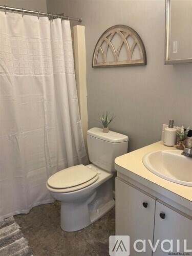 A white toilet and sink in a bathroom.
