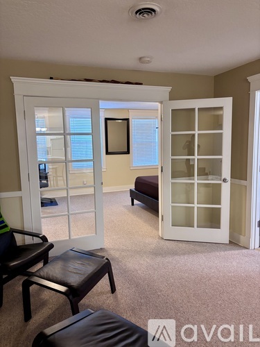 A living room with a couch, chair, and a window.