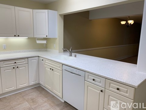 A kitchen with white cabinets and a countertop.