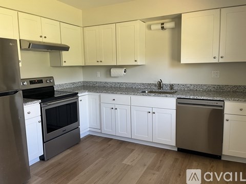 A kitchen with white cabinets and a granite countertop.