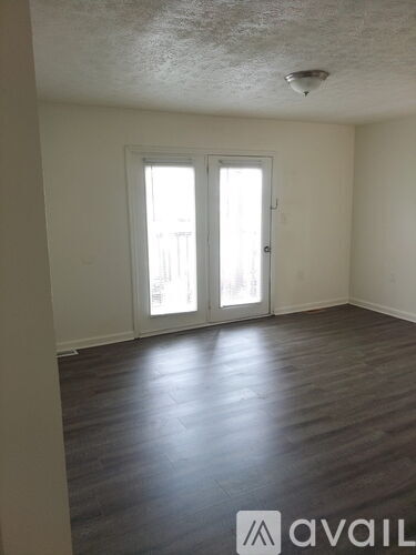 A room with a sliding door and wooden flooring.