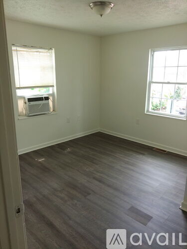 A room with a window and a wall-mounted air conditioner.