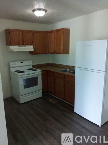 A small kitchen with a white fridge and a white stove.