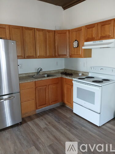 A kitchen with wooden cabinets and a white stove top oven.