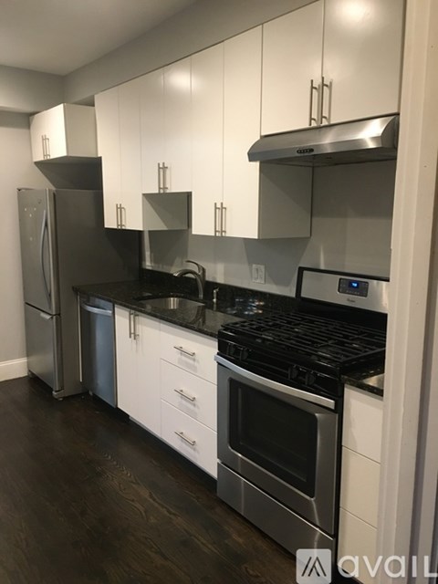 A modern kitchen with stainless steel appliances and white cabinets.