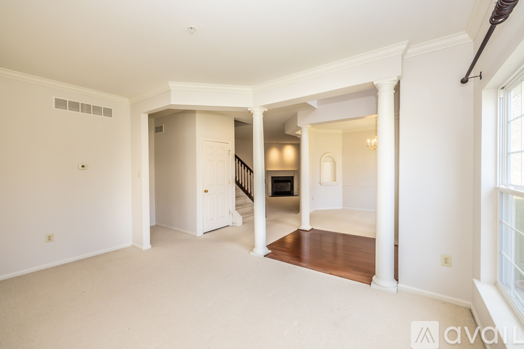 A spacious living room with a staircase leading to the upper floor.