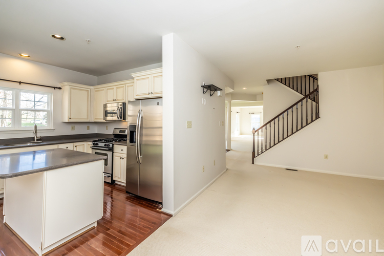 A kitchen with white cabinets and a stainless steel refrigerator.