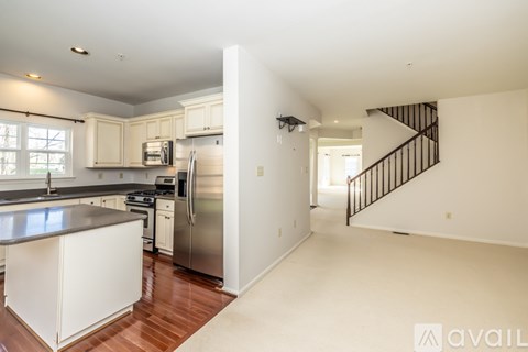 A kitchen with white cabinets and a stainless steel refrigerator.