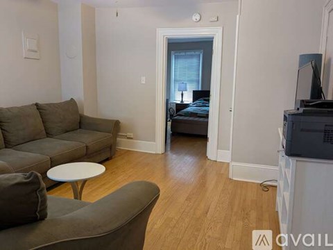 A living room with a grey couch and a white table.