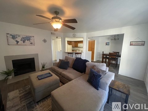 A living room with a beige couch and a fireplace.