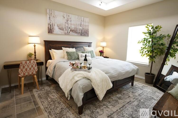 A bedroom with a large bed and a painting on the wall.
