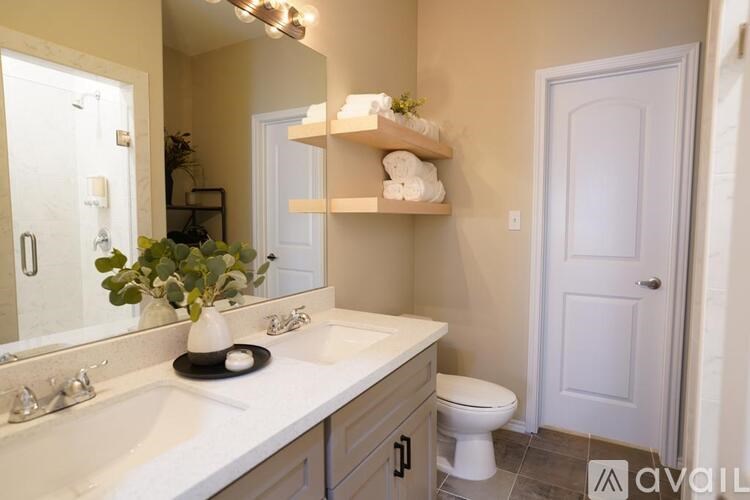 A bathroom with a white countertop and a white toilet.