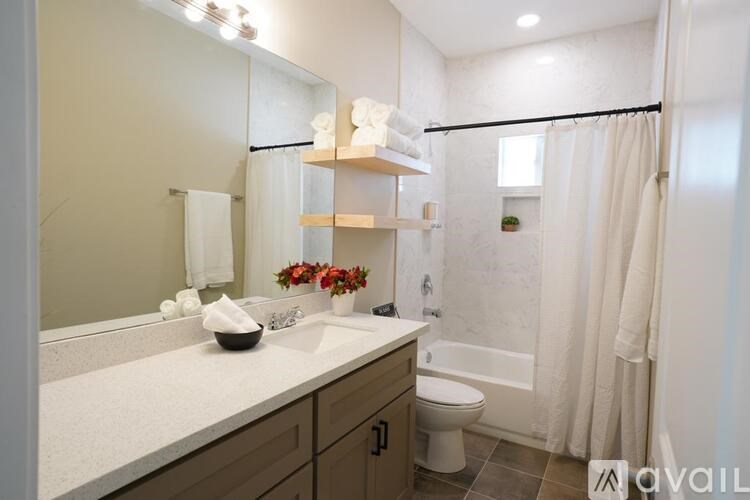 A bathroom with a white countertop and a white toilet.
