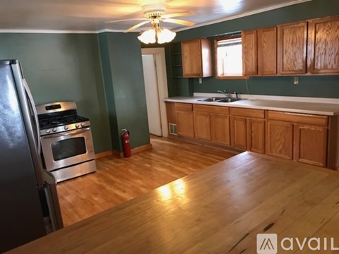 A kitchen with wooden cabinets and a stainless steel refrigerator.