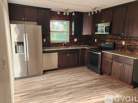 A kitchen with wooden cabinets and a black stove top oven.