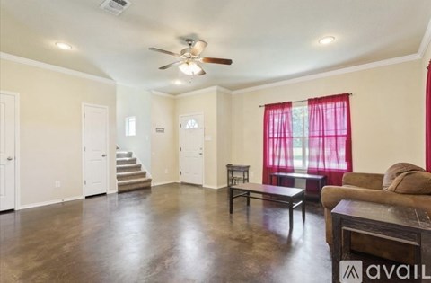 A living room with a couch, a coffee table, and a staircase.