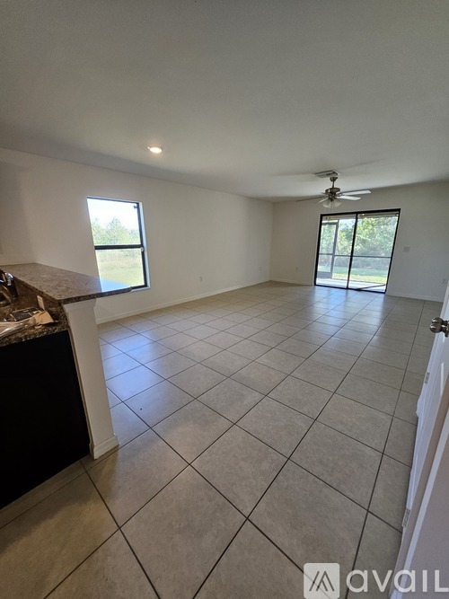 A spacious room with a tiled floor and a ceiling fan.