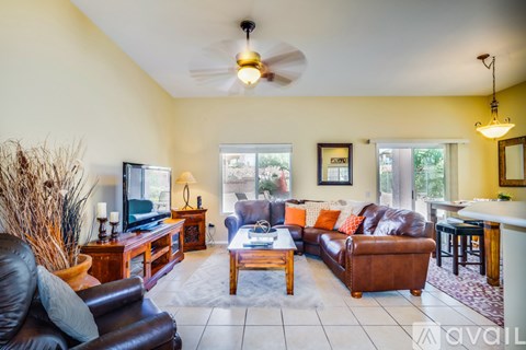 A living room with a brown leather couch and a wooden coffee table.