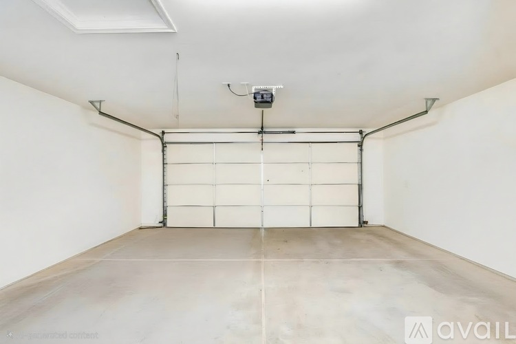 A spacious garage with a white door and a concrete floor.