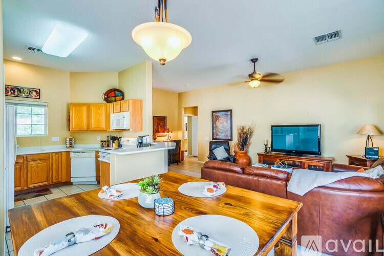 A well-lit, spacious kitchen and living room with a dining table set for two.