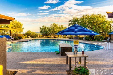 A pool with a table and chairs and umbrellas.