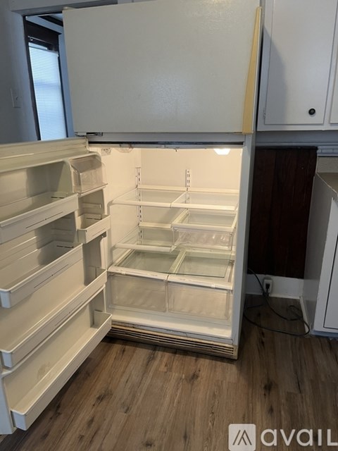 A white refrigerator with its door open is in a kitchen.