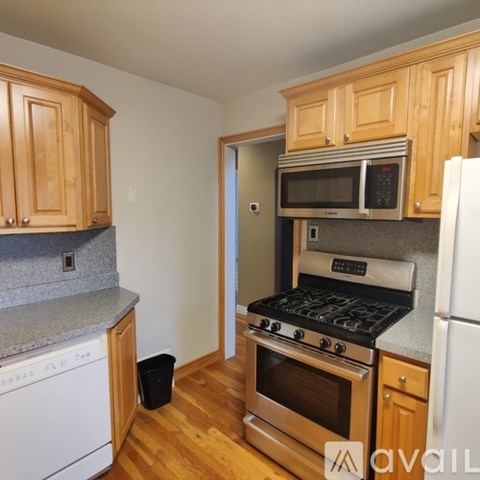 A kitchen with wooden cabinets and a stove top oven.