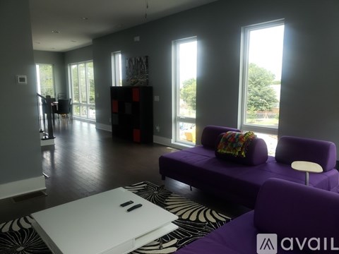 A living room with purple couches and a white coffee table.
