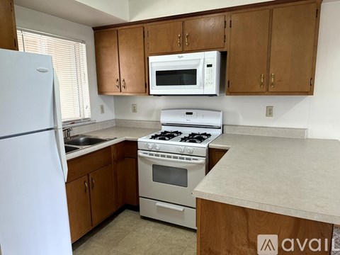 A kitchen with a white fridge, a white microwave, a white stove and white oven.