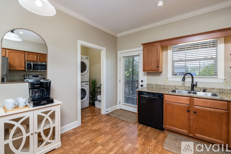 A kitchen with wooden cabinets and a black dishwasher.