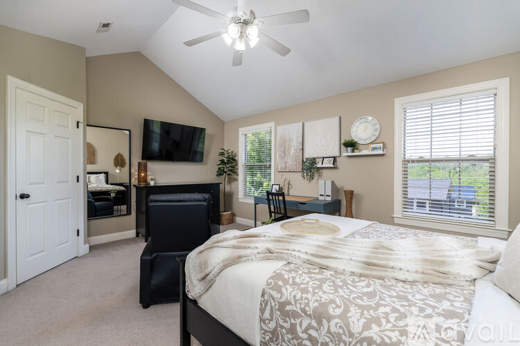 A bedroom with a large bed and a flat screen TV mounted on the wall.