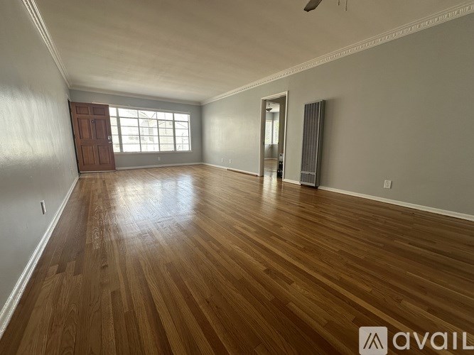 A room with wooden flooring and a window.