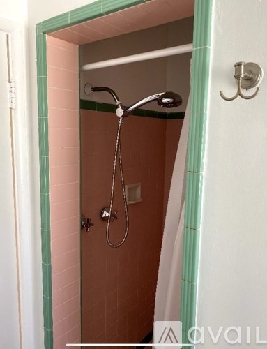 A bathroom with a pink tiled shower.