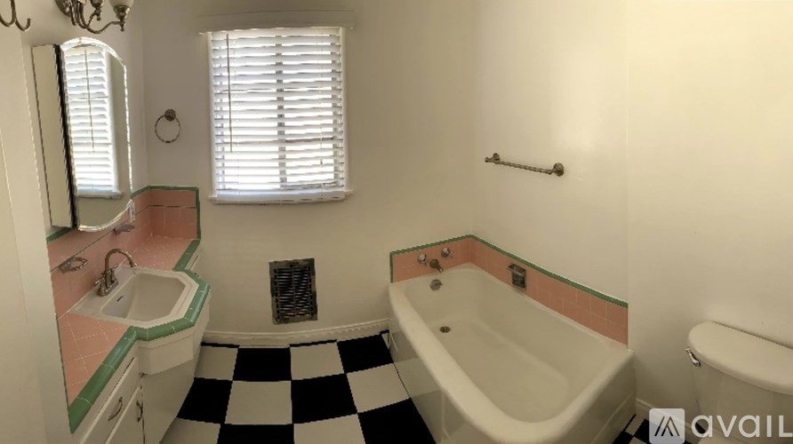 A bathroom with a checkered floor and a bathtub.