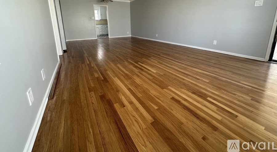 A room with wooden flooring and a white wall.