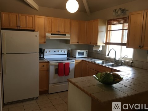 A kitchen with wooden cabinets and a white refrigerator.