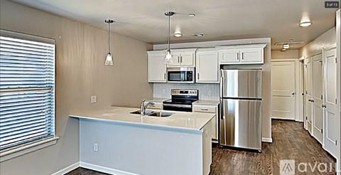 A kitchen with white cabinets and a stainless steel refrigerator.