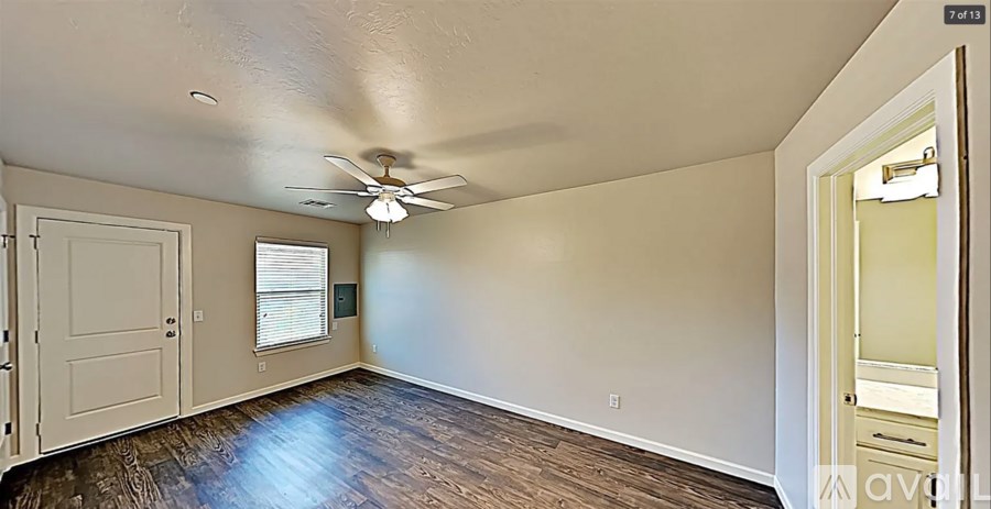 A room with a ceiling fan and a window with blinds.