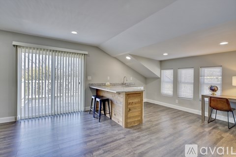 A kitchen with a bar stool and a counter with a sink.