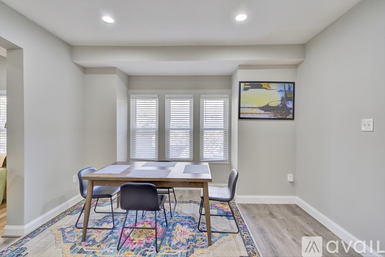 A dining room with a wooden table and chairs.