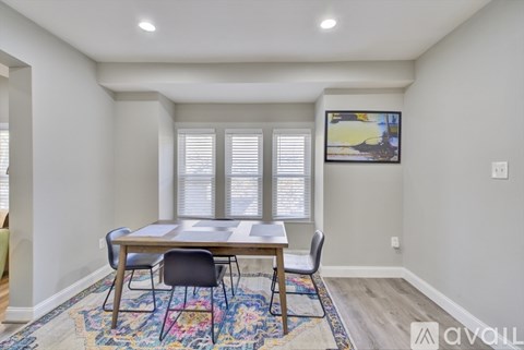 A dining room with a wooden table and chairs.