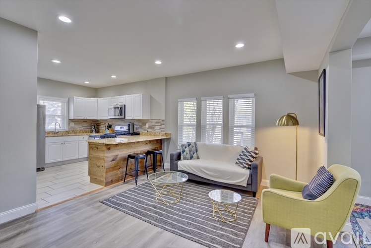 A living room with a yellow chair and a white couch.