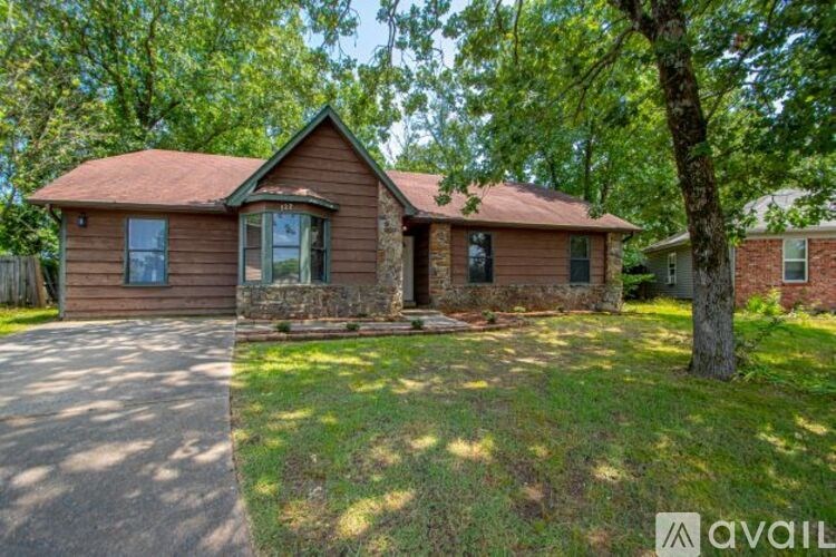A house with a brown roof and a tree in front.