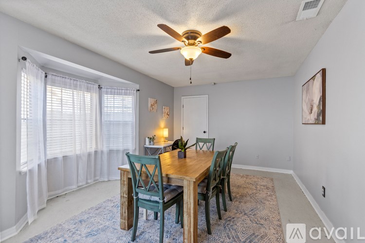 A dining room with a table and chairs.